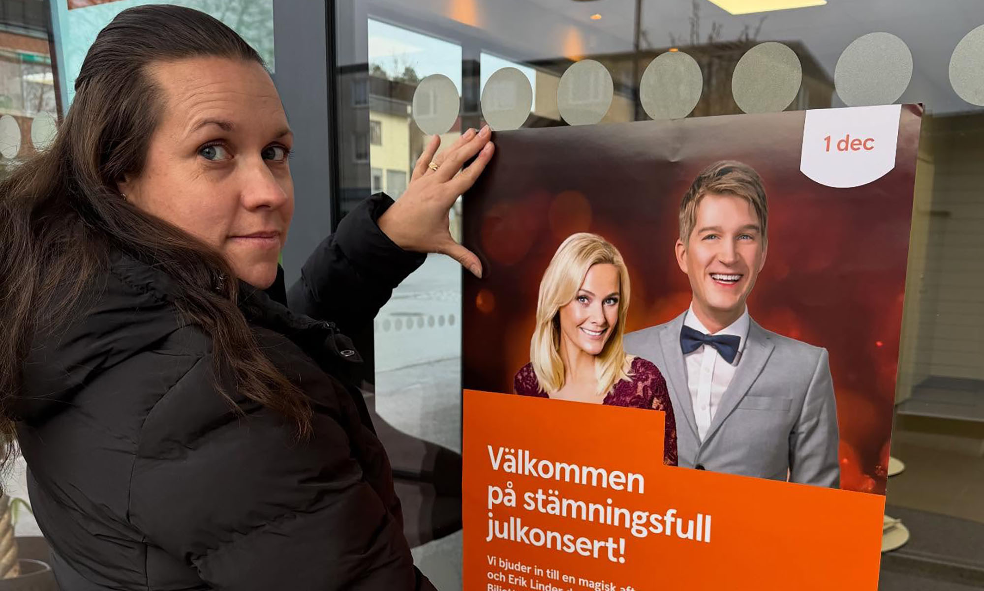 En kvinna håller upp en affisch.