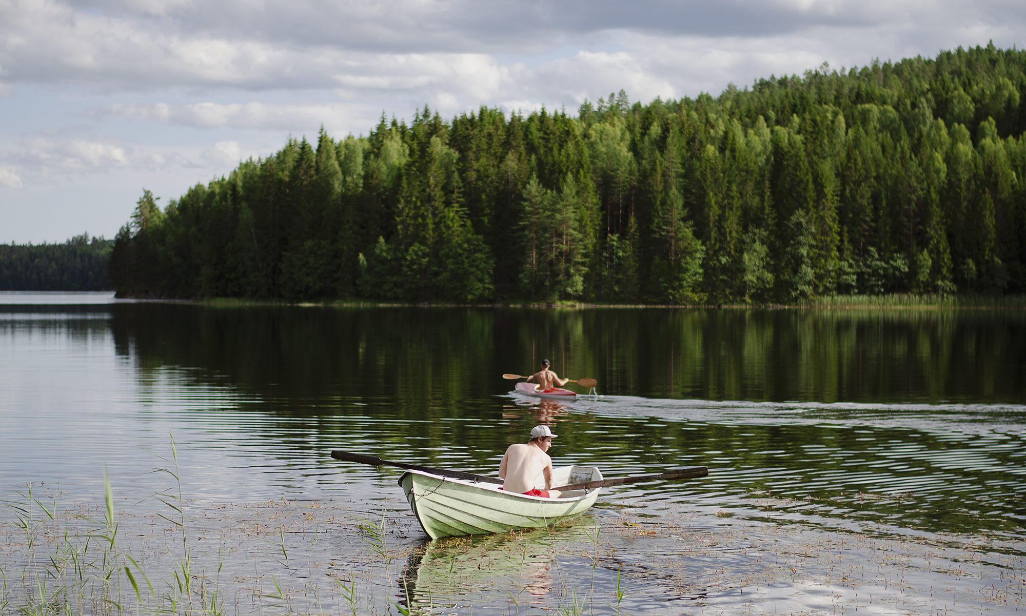 Två män på sjö i båt och kanot
