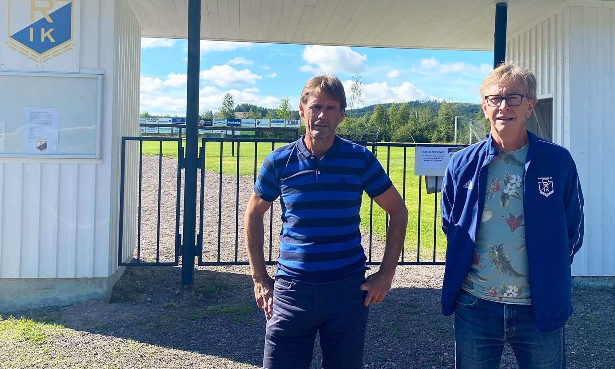 Två män vid en fotbollsplan.